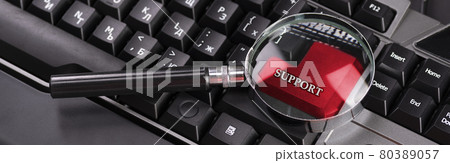Black keyboard from a computer with a magnifying glass. Enter and switch keys. Tool. Press. Red enter button enlarged with magnifying glass 80389057