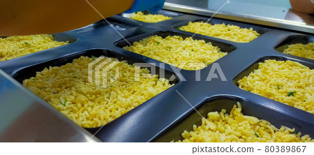 Frozen fried rice with egg in plastic tray waiting for top seal label with thermoforming machine in food factory. Frozen food industry. Ready meal process in manufacturing. Food packaging industry. Frozen fried rice with egg in plastic tray waiting for top seal label with thermoforming machine in food factory. Frozen food industry. Ready meal process in manufacturing. Food packaging industry. 80389867