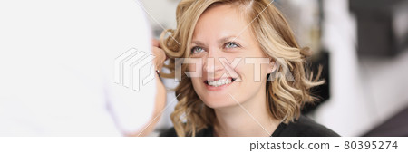 Portrait of smiling woman who has her hair done from curls Portrait of smiling woman who has her hair done from curls 80395274