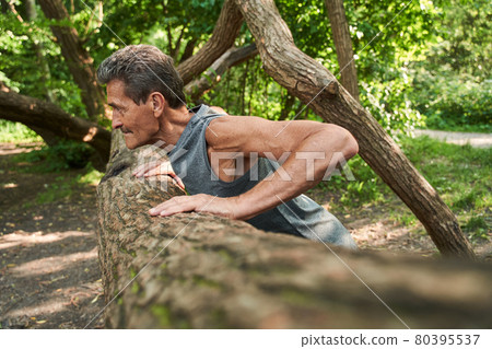 Senior fitness man training push up outside in the forest in summer Senior fitness man training push up outside in the forest in summer 80395537