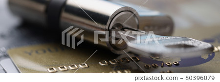 Lock with key rests on plastic credit cards 80396079
