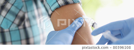 Doctor gives patient an injection in shoulder Doctor gives patient an injection in shoulder 80396108