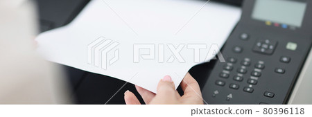 Person takes out white sheet from laser printer 80396118