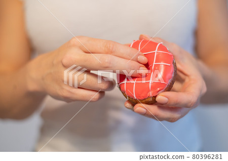 Faceless woman holding a donut imitating sexual intercourse. A metaphor for masturbation Faceless woman holding a donut imitating sexual intercourse. A metaphor for masturbation 80396281