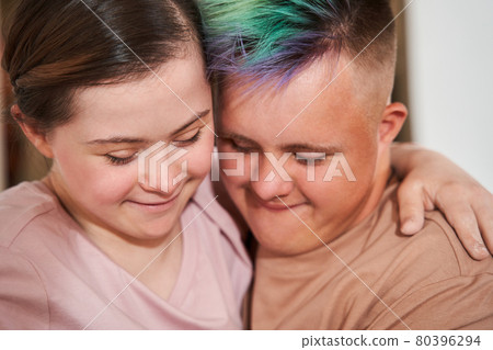 Girl with special needs embracing tight her boyfriend with colored hair 80396294