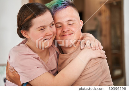 Girl with special needs embracing tight her boyfriend with colored hair 80396296