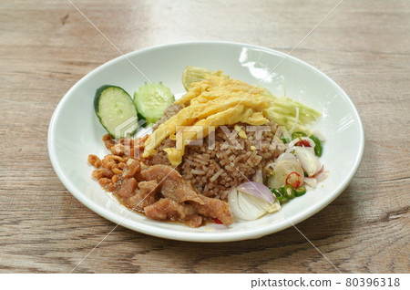 rice mixed with shrimp paste topping slice Thai egg omelette couple sweet pork in gravy and vegetable on plate rice mixed with shrimp paste topping slice Thai egg omelette couple sweet pork in gravy and vegetable on plate 80396318