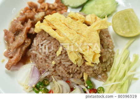 rice mixed with shrimp paste topping slice Thai egg omelette couple sweet pork in gravy and vegetable on plate rice mixed with shrimp paste topping slice Thai egg omelette couple sweet pork in gravy and vegetable on plate 80396319