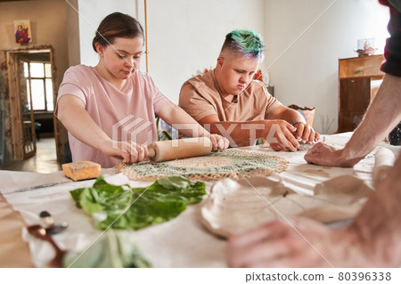 Down syndrome couple transferring patterns at their future plates 80396338