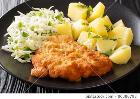 Polish Breaded Pork Cutlets Kotlet Schabowy with boiled potatoes and cabbage salad close-up in a plate. Horizontal Polish Breaded Pork Cutlets Kotlet Schabowy with boiled potatoes and cabbage salad close-up in a plate. Horizontal 80396798