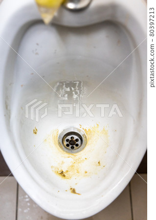 Close-up of dirty and smelly urinal bowl with limescale stain deposits 80397213