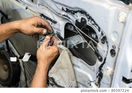 Auto technician diagnose and fixing wiring problem of car door Auto technician diagnose and fixing wiring problem of car door 80397224