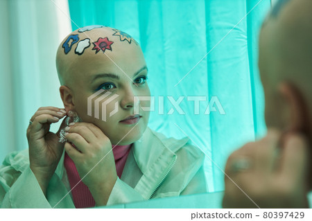 Woman looking at her reflection and puts on the earnings while preparing for the walking 80397429