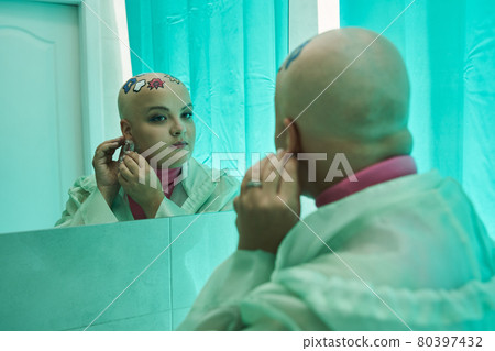 Woman looking seriously at her reflection and keeping on the earnings Woman looking seriously at her reflection and keeping on the earnings 80397432