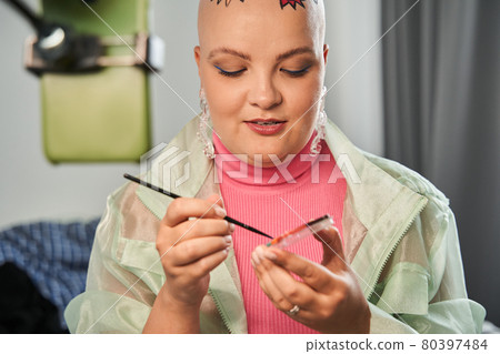 Blogger broadcasting video about makeup while sitting in front of the smartphone Blogger broadcasting video about makeup while sitting in front of the smartphone 80397484
