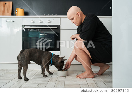 Woman spending time with her dog during a breakfast in the dining room Woman spending time with her dog during a breakfast in the dining room 80397543
