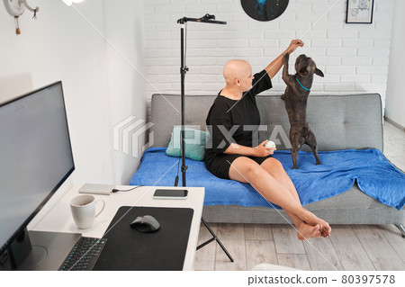 Bald woman playing with her active french bulldog Bald woman playing with her active french bulldog 80397578