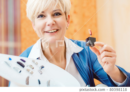 Senior woman with impairment choosing hearing aid Senior woman with impairment choosing hearing aid 80398118