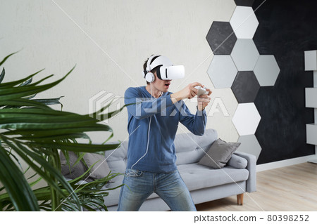 Man with virtual reality headset is playing game. 80398252
