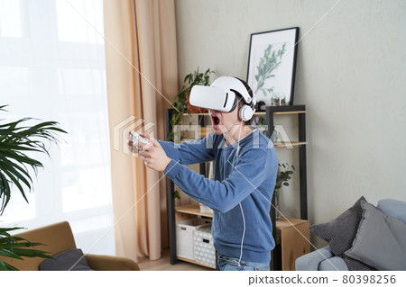 Man with virtual reality headset is playing game. 80398256