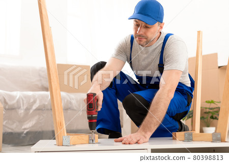 Handyman Assembling Wooden Table With Electric Drill Indoor Handyman Assembling Wooden Table With Electric Drill Indoor 80398813