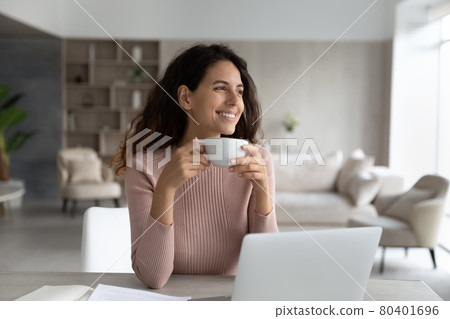 Smiling Latino woman drink coffee work on laptop Smiling Latino woman drink coffee work on laptop 80401696