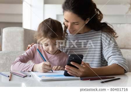 Loving Latin mom and daughter drawing using cell Loving Latin mom and daughter drawing using cell 80401716
