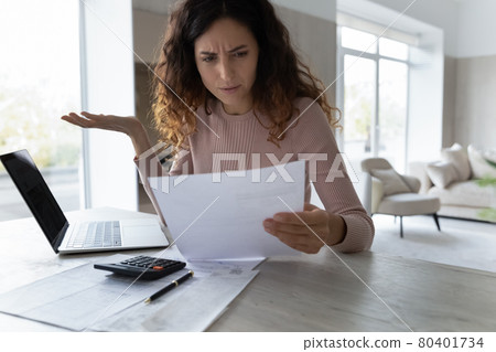 Confused Latin woman distressed with news in document 80401734