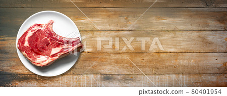 Beef prime rib and plate isolated on old wooden background. Horizontal banner Beef prime rib and plate isolated on old wooden background. Horizontal banner 80401954