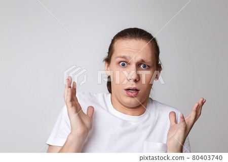 scared man in t-shirt isolated on gray background. scared man in t-shirt isolated on gray background. 80403740