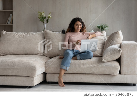Smiling Latin woman talk on webcam call on laptop Smiling Latin woman talk on webcam call on laptop 80403873