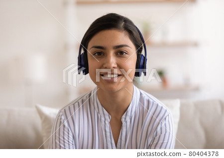 Head shot portrait smiling Indian woman in headphones chatting online Head shot portrait smiling Indian woman in headphones chatting online 80404378