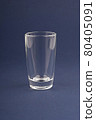 Empty shot glass stack on a dark blue background. 80405091