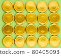 Lids for jars of gold color top view on a green background. 80405093