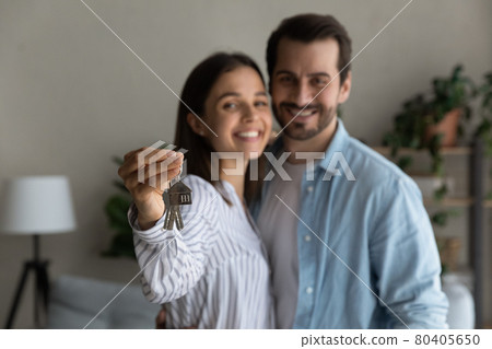 Happy married couple holding keys from new bought house, closeup 80405650