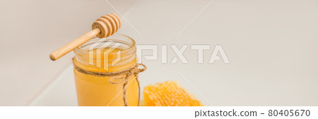 Honey pot with honey dipper and natural honeycomb banner background 80405670