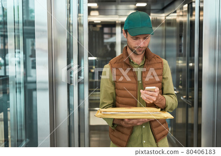 Delivery Guy Using Smartphone 80406183