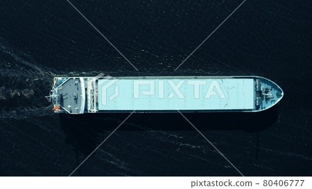 Aerial overhead view of an unknown cargo ship moving at sea 80406777