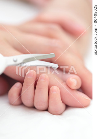 Mom cutting the nails of a newborn baby's hand 80408028