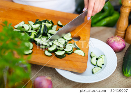Female hands cuts vegetables on cutting board 80410007