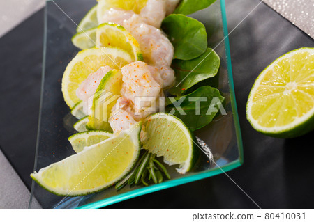 Ceviche from alaska pollock on a glass plate with lime and herbs 80410031