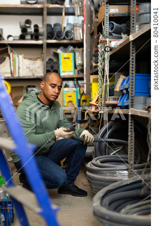 Man choosing plastic pipes in plumbing store Man choosing plastic pipes in plumbing store 80410041