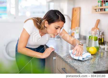 Colombian housewoman is cleaning furniture at home kitchen Colombian housewoman is cleaning furniture at home kitchen 80410180