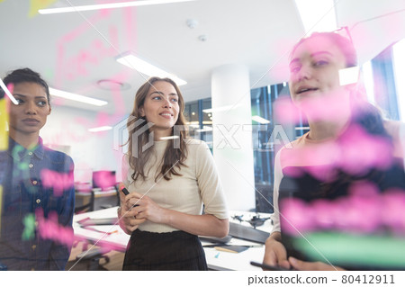 Diverse group of creative colleagues discussing work and brainstorming at meeting 80412911