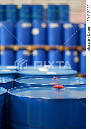 Red cap on blue chemical barrels.  Many barrels line up in the background. 80412912