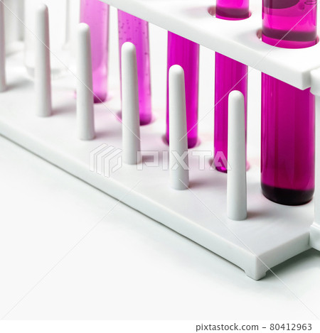 White test tube stand with  test tube containing Potassium Permanganate Liquid, chemicals ingredient on white laboratory table. 80412963