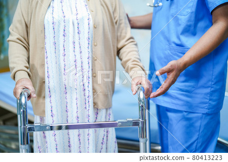 Asian nurse physiotherapist doctor care, help and support senior or elderly old lady woman patient walk with walker at hospital ward : healthy strong medical concept.. 80413223