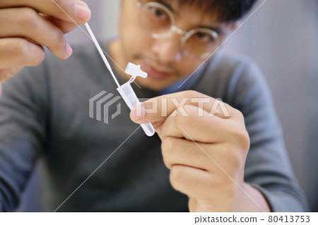 Man uses cotton swab to test for Covid-19 Insert a reagent bottle to look for what is believed to be a virus. Man uses cotton swab to test for Covid-19 Insert a reagent bottle to look for what is believed to be a virus. 80413753