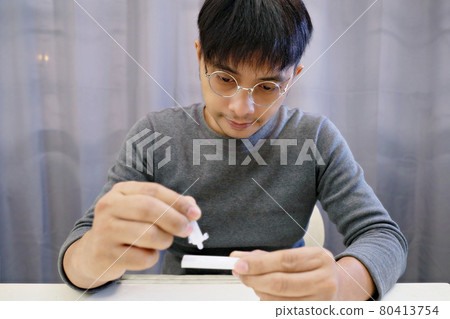 A man is dripping with a solution that has undergone a process of mixing COVID-19 tests. A man is dripping with a solution that has undergone a process of mixing COVID-19 tests. 80413754