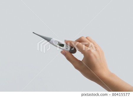 Hand hold an electronic medical thermometer isolated on white background. Fever or Diagnosis self check up. Medical and healthcare equipment. Coronavirus covid-19 outbreak. 80415577